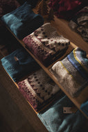 Stack of folded sweaters on a wooden surface